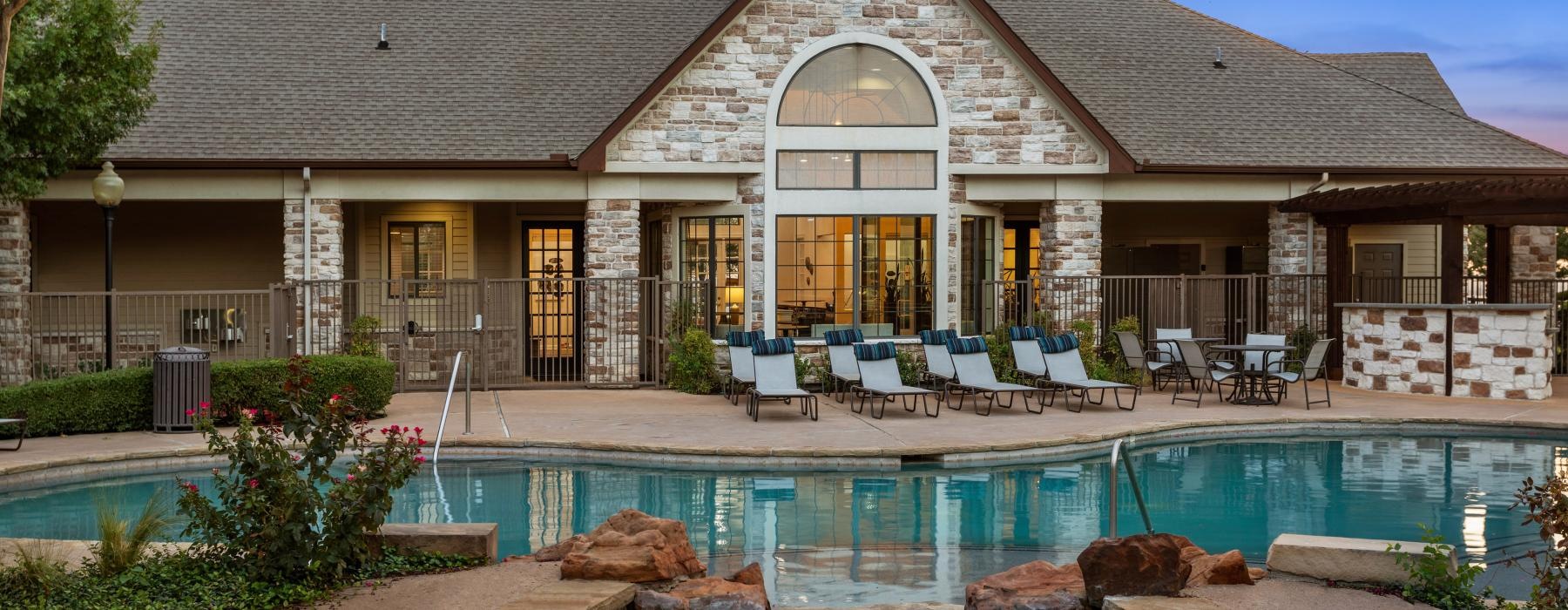 clubhouse exterior with view of the pool in the evening 